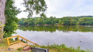 Une jetée en bois mène à un banc d’où l’on peut admirer un lac paisible, entouré d’arbres.