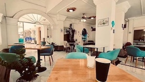Une salle à manger spacieuse, dotée de hauts plafonds, de fenêtres en arc de cercle et de mobilier moderne.