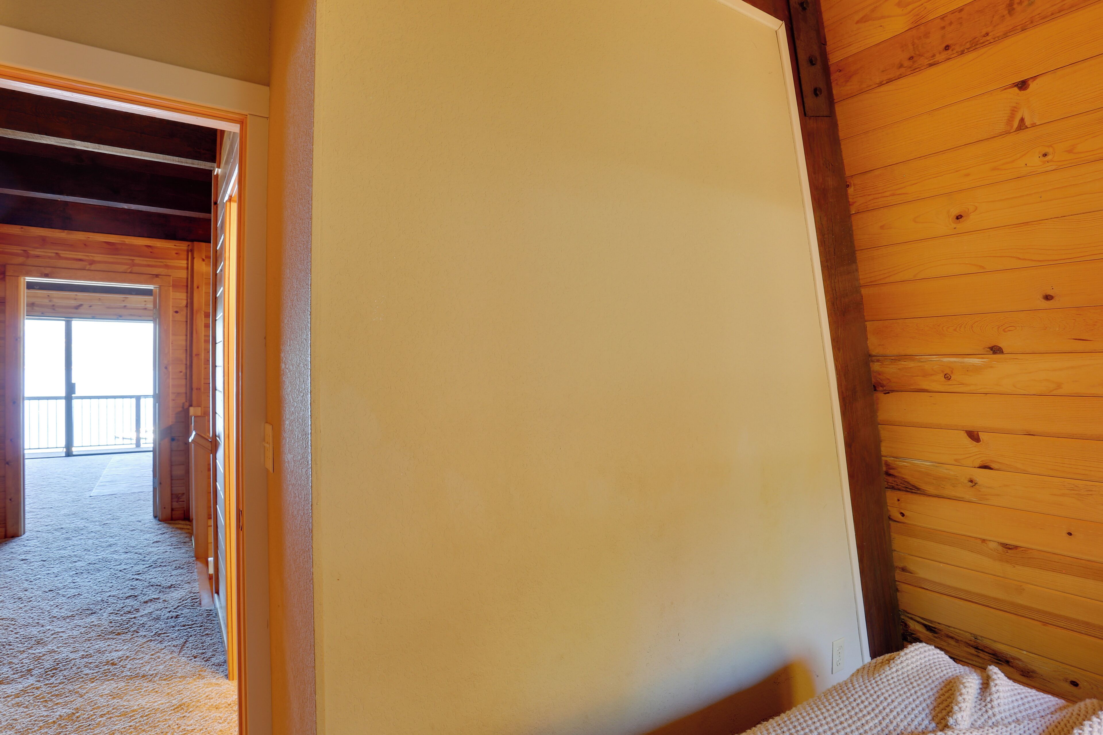 Una habitación con paredes de madera y un ventanal grande.