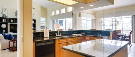 A modern kitchen with a dishwasher, wooden cabinets, and a large island.