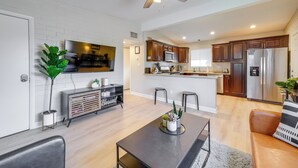 A modern kitchen with a central island, stainless steel appliances, and wooden cabinets.