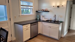 A compact kitchen with white cabinets, a dishwasher, a sink, and a window with blinds. - Historic Newport...steps to downtown/wharfs dining, shopping, attractions (Newport)