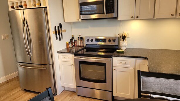 A modern kitchen with stainless steel appliances, including a refrigerator, oven, and microwave. - Historic Newport...steps to downtown/wharfs dining, shopping, attractions (Newport)