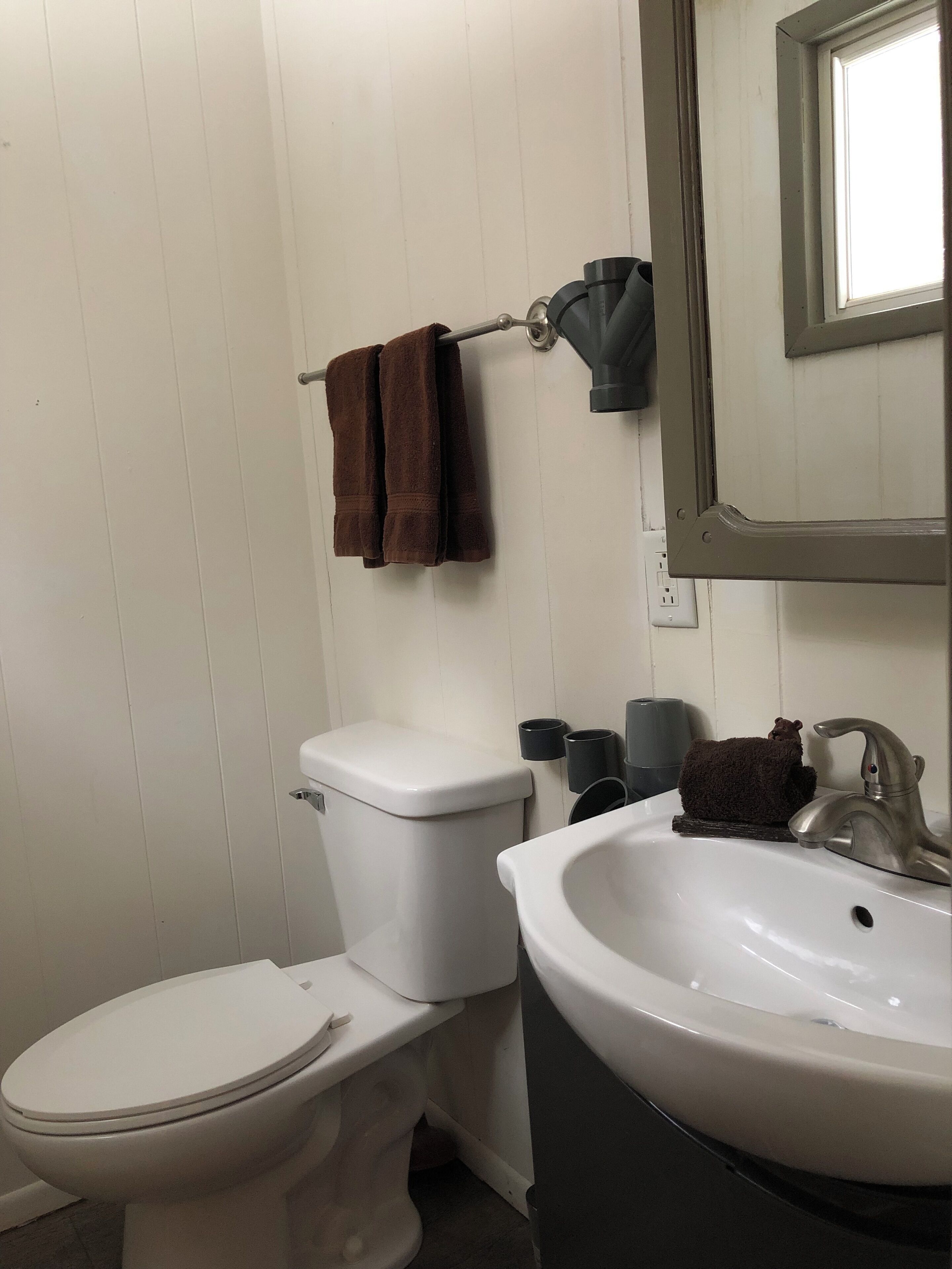 A bathroom with a toilet, sink, and towel rack.