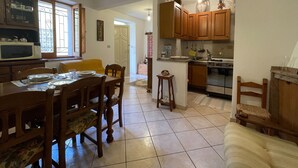 A spacious kitchen with wooden cabinets, a microwave, and a dining area with a table and chairs.