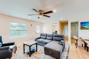 Relax in this inviting living space with a comfortable sofa, dining area, and large window.