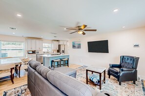 Relax in this stylish living space with a comfortable sofa, armchair, and dining area.