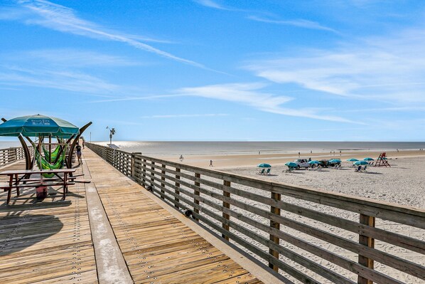 Walk along the boardwalk to the sandy beach, where a hammock and umbrella invite relaxation.