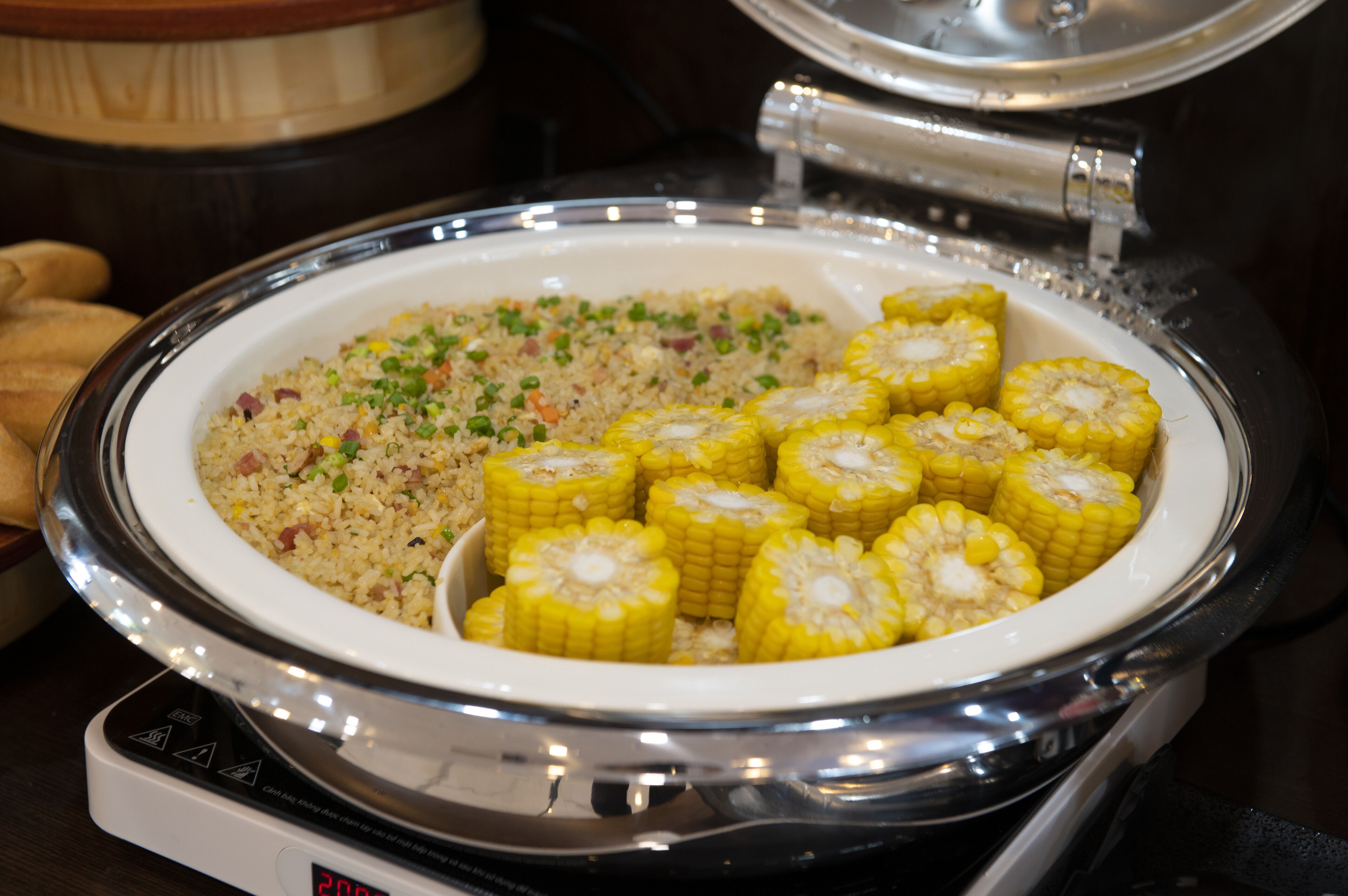 A buffet with a plate of fried rice and corn on the cob.