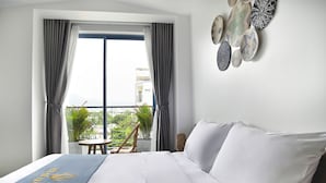 Habitación de hotel con una cama grande, vistas al exterior y un elemento decorativo en la pared.