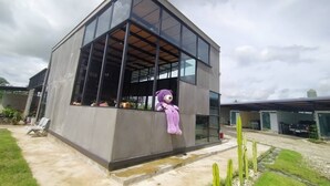 Un edificio moderno de dos pisos con amplios ventanales y fachada de concreto.