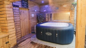 Une salle de spa en bois avec un jacuzzi, des murs en bois et un panneau affichant des citations inspirantes.