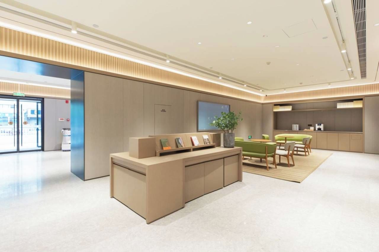 A modern reception area with a reception desk, seating area, and a large window.