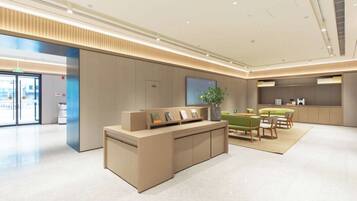 A modern reception area with a reception desk, seating area, and a large window.