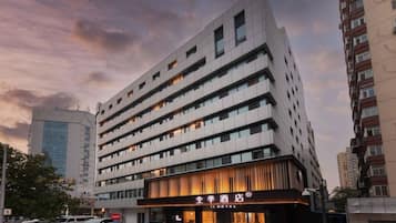 A multi-story hotel with a modern facade, large windows, and a prominent entrance with a sign.