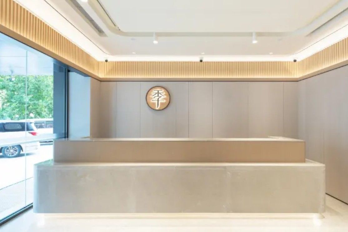 A reception area with a modern design, a reception desk, and a wall-mounted sign.