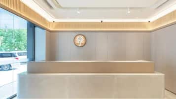 A reception area with a modern design, a reception desk, and a wall-mounted sign.