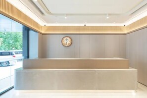 A reception area with a modern design, a reception desk, and a wall-mounted sign. - Ji Hotel (Beijing)