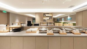 En modern buffé med flera serveringsstationer, ett centralt område för presentation av maten och en ren och väl upplyst miljö.