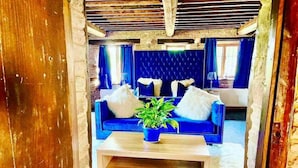 A cozy living room with a blue sofa, white fluffy rug, and a wooden coffee table. - 16th Cent,6 bed house,15 People (Monmouthshire)
