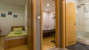 Una camera da letto con un letto, un armadio in legno e un bagno con doccia.