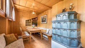 Een houten interieur met een eethoek, een bank en een kast met een trofee.