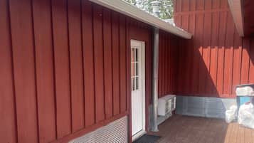 Enjoy outdoor seating under a sheltered area with a door leading to the interior.