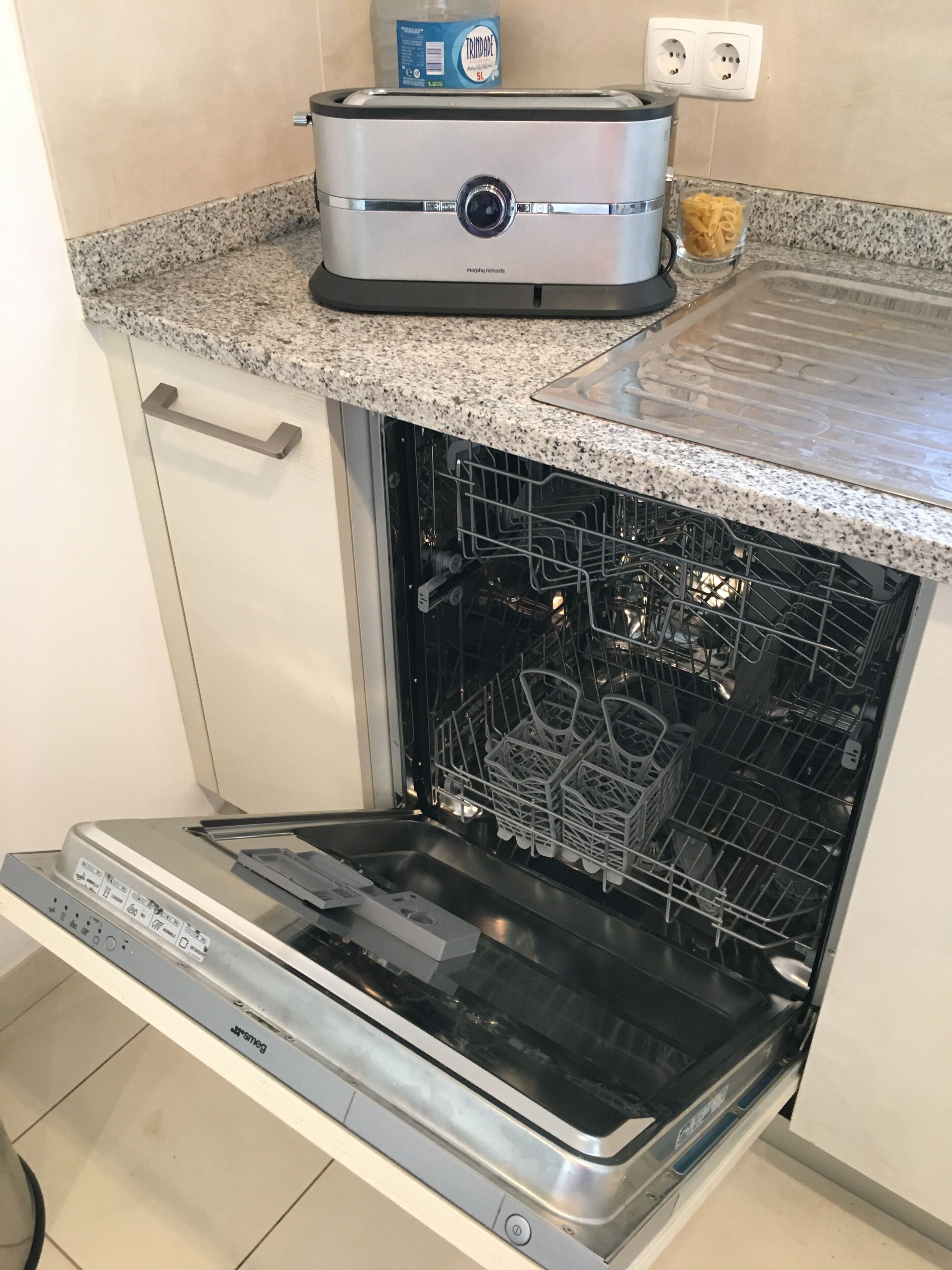 Une cuisine compacte équipée d’un lave-vaisselle encastré, d’un grille-pain et d’un petit plan de travail.