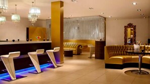 A modern hotel lobby with a reception desk, seating area, and a large mirror. - VILLA TORTUGA BEACH RESORT (Sal)