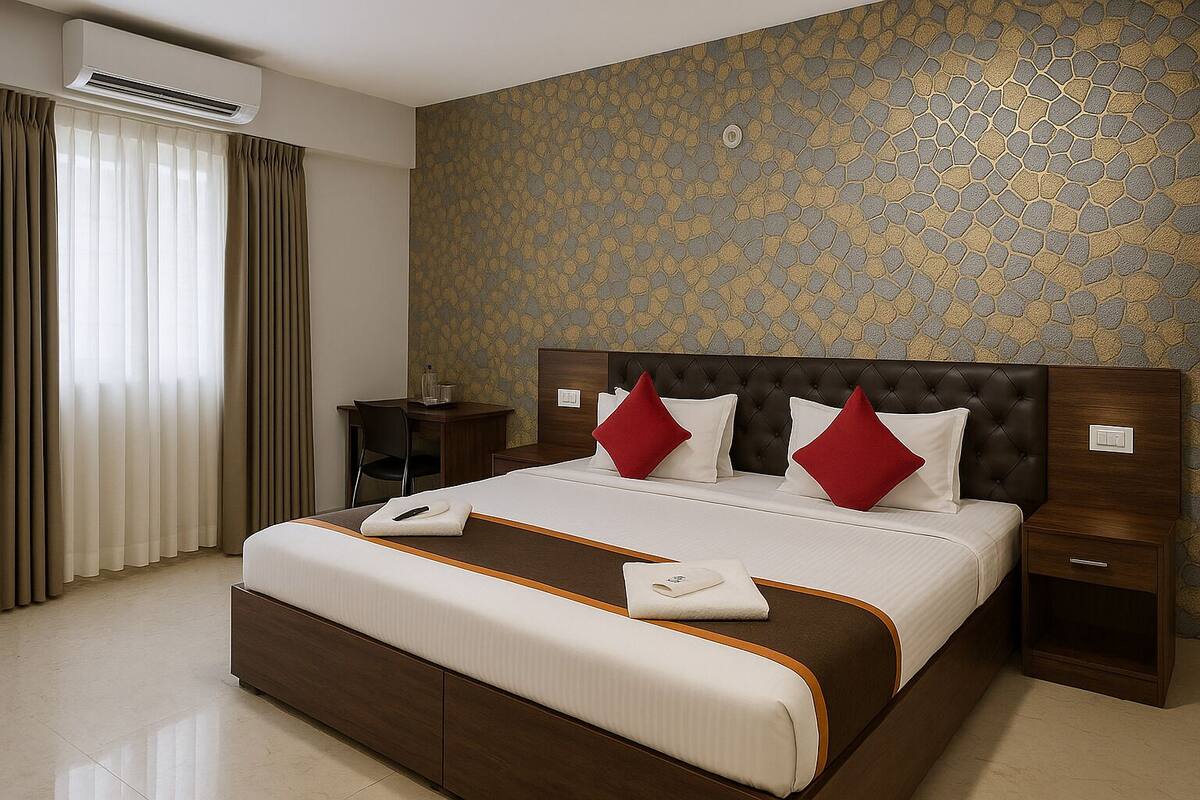 A hotel room with a large bed, a desk, and a chair.