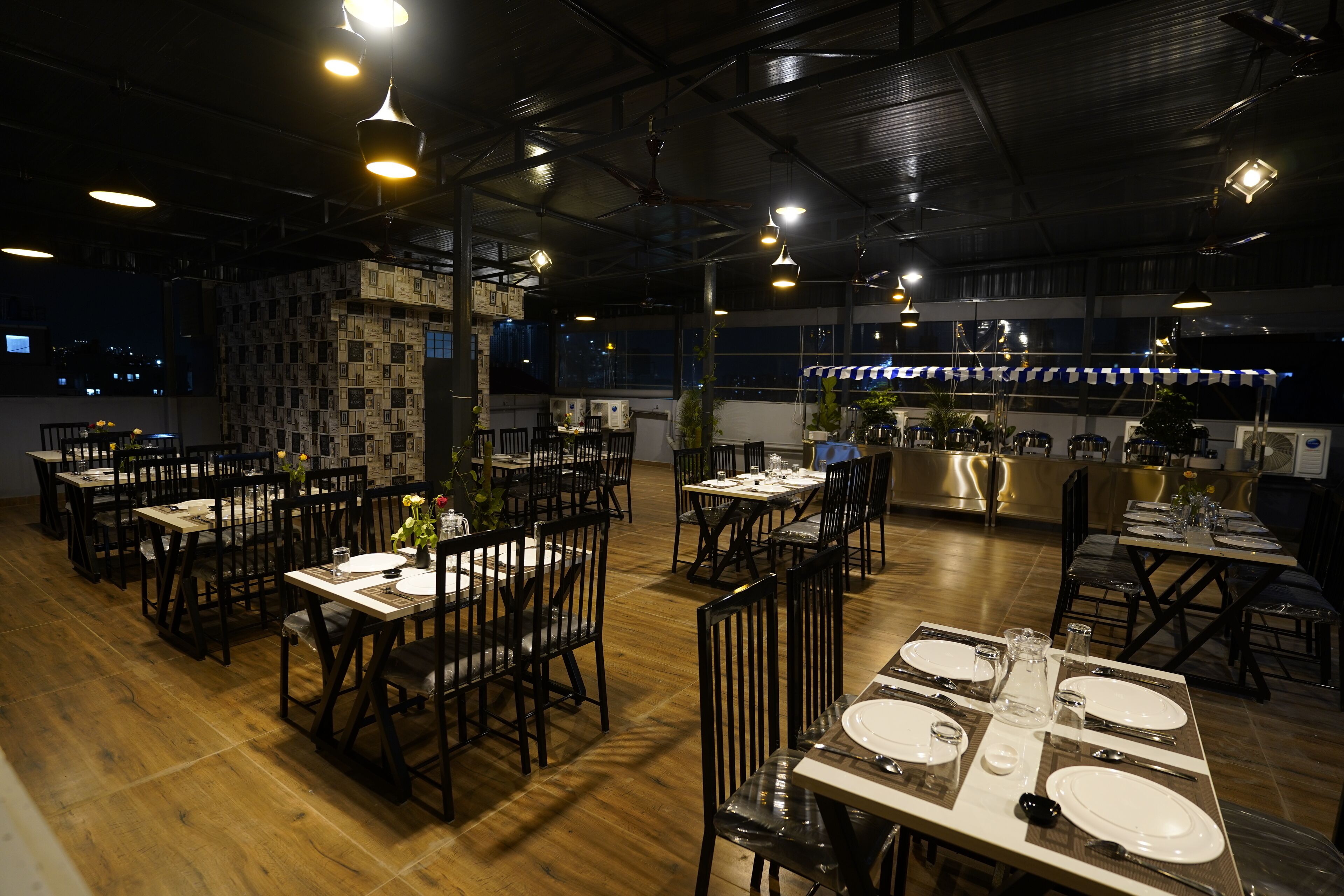 A restaurant with multiple dining tables set for guests, featuring a mix of wooden and metal chairs.