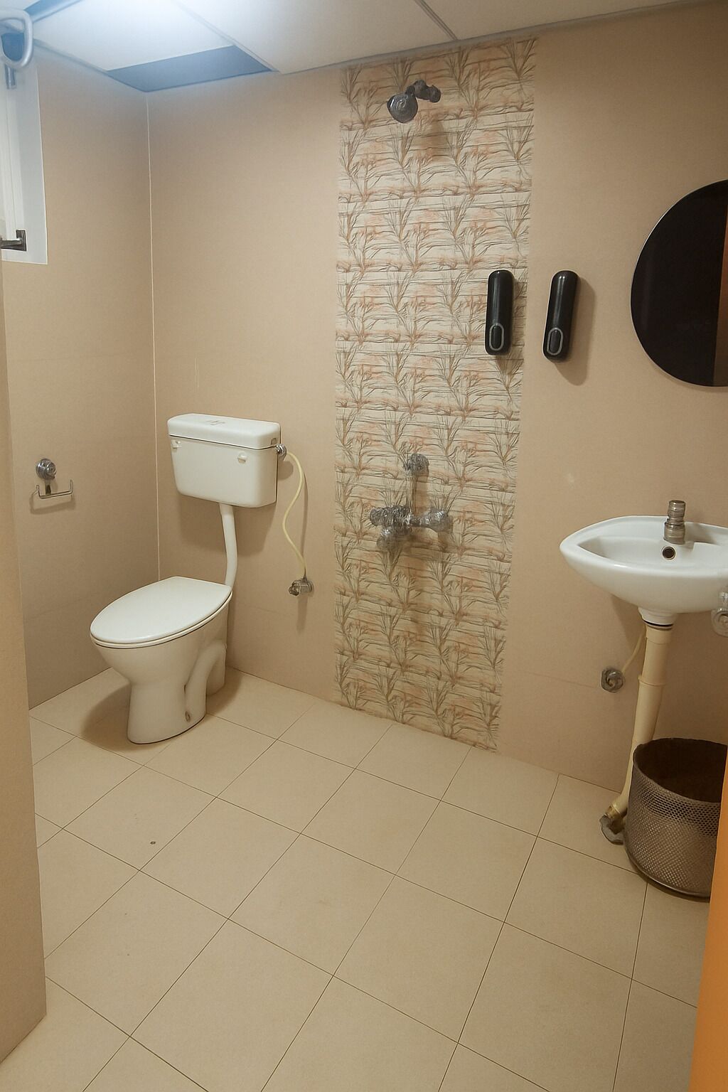 A bathroom with a toilet, shower, and sink.
