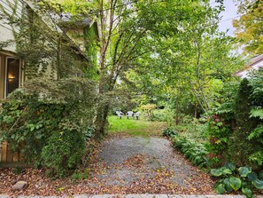 A pathway leading to a house with a garden, a wooden fence, and a grassy area. - Cozy 3 Bedroom House in Downtown Ithaca (Ithaca)