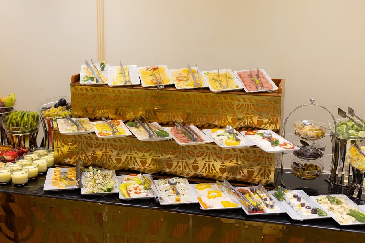 A buffet with various food items and utensils.