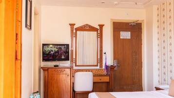 A hotel room with a bed, a desk, a television, and a wardrobe.