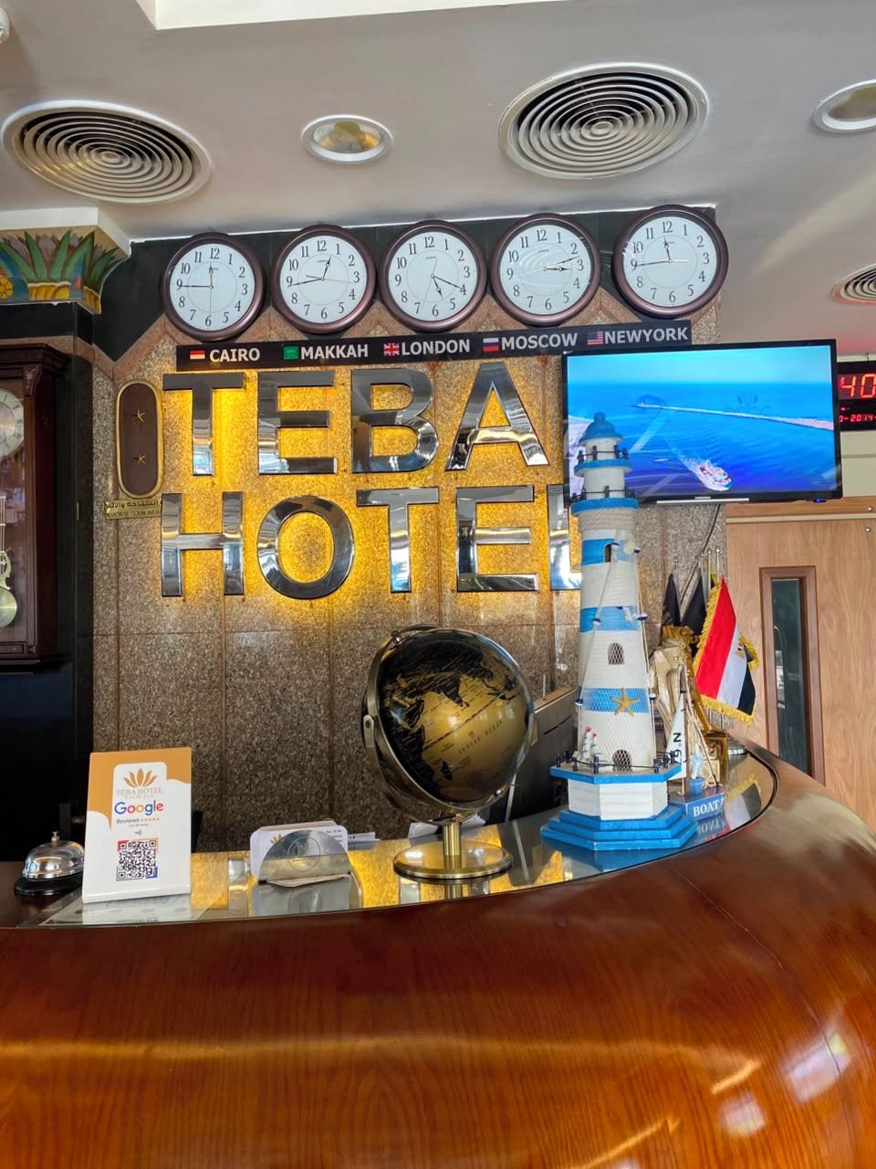 Una recepción de hotel con relojes que muestran la hora en El Cairo, La Meca, Londres, Moscú y Nueva York.