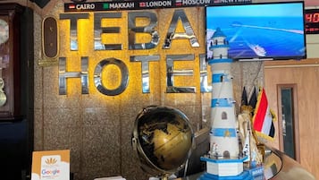 Una recepción de hotel con relojes que muestran la hora en El Cairo, La Meca, Londres, Moscú y Nueva York.