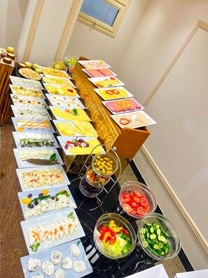 A buffet table with various food items and garnishes.