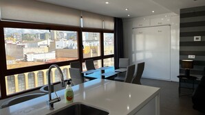 Une cuisine moderne dotée d’une grande fenêtre, d’un évier et d’un coin repas avec des chaises et une table.