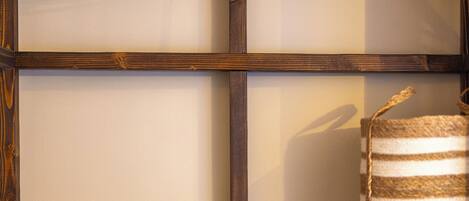Een houten plank met twee houten kapstokken en een geribbelde mand.