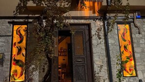 Ein Hotelzugang mit einer dunklen Holztür, beleuchtet durch warmes Licht.