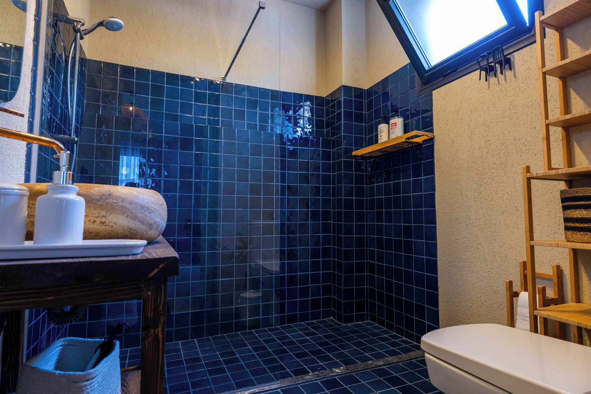 A bathroom with a shower, a toilet, and a sink.