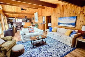Un intérieur en bois avec deux canapés, une table basse et un tapis à motifs.