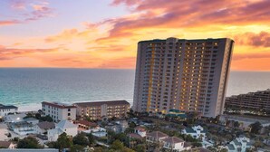 A coastal hotel with multiple buildings, a large central structure, and a view of the ocean at sunset. - Destin/Miramar Beach Townhouse, 3-Min Walk to Sand, Sleeps 6, Pet Friendly (Miramar Beach)