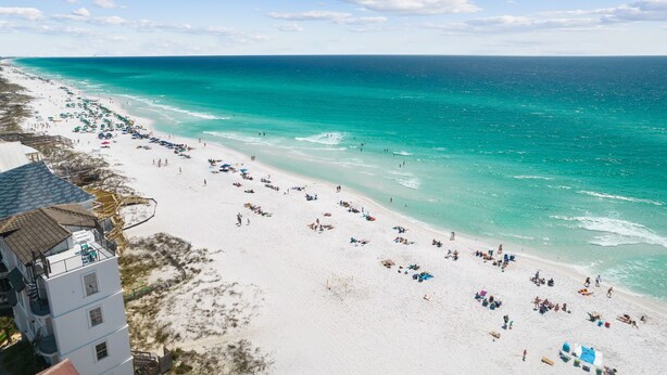 A beach with white sand, clear turquoise water, and a few buildings in the background. - Destin/Miramar Beach Townhouse, 3-Min Walk to Sand, Sleeps 6, Pet Friendly (Miramar Beach)