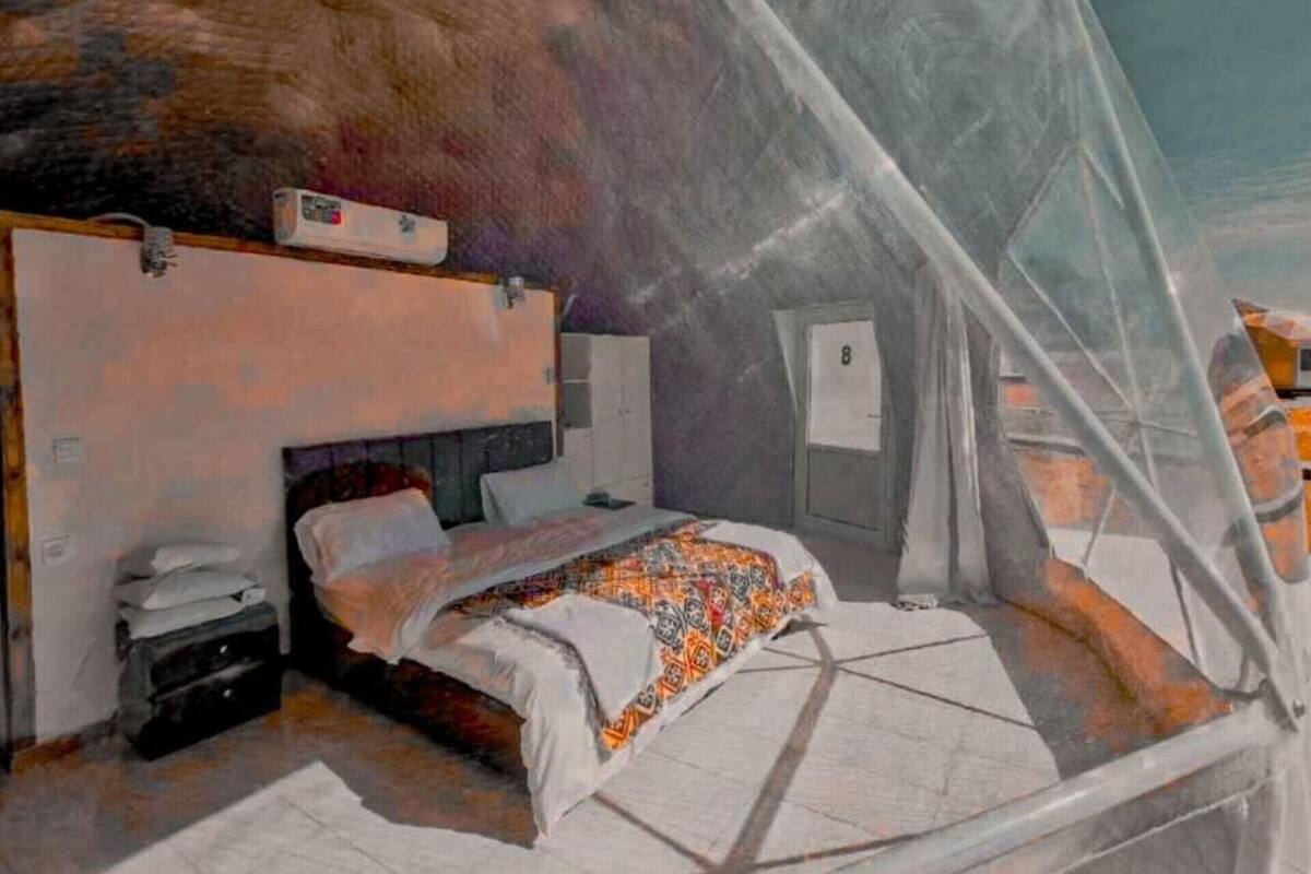 Een kamer met een bed, een bureau en een stoel. Er is een raam met uitzicht op het exterieur.