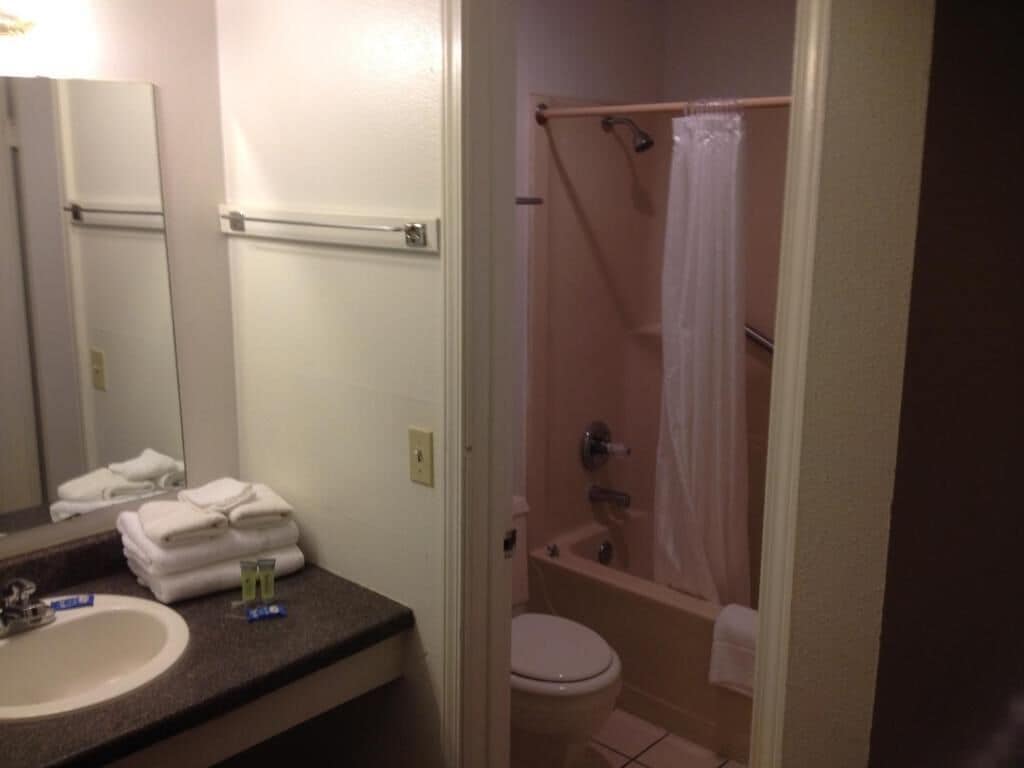Un baño con lavamanos, espejo y zona de ducha con cortina.