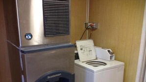 A compact laundry area with a stainless steel appliance and a white washing machine. - American Dream (Elk City)