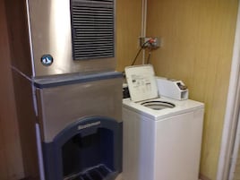 A compact laundry area with a stainless steel appliance and a white washing machine.