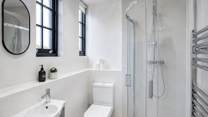 A modern bathroom with a glass-enclosed shower, a white sink, and a toilet. - Modern 1bdr Flat in Old Street, shoreditch, hoxton (London)